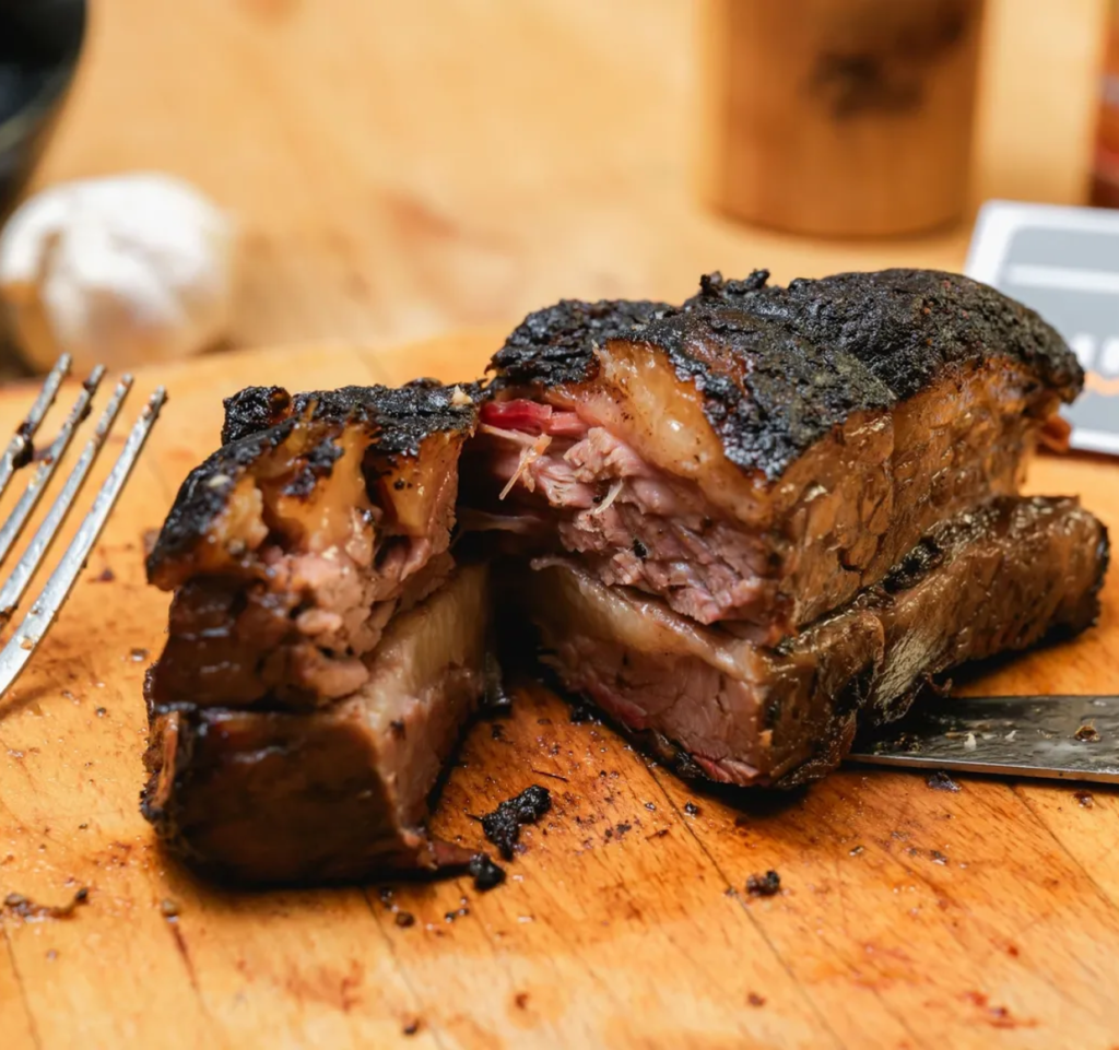 Juicy smoked brisket on wooden board