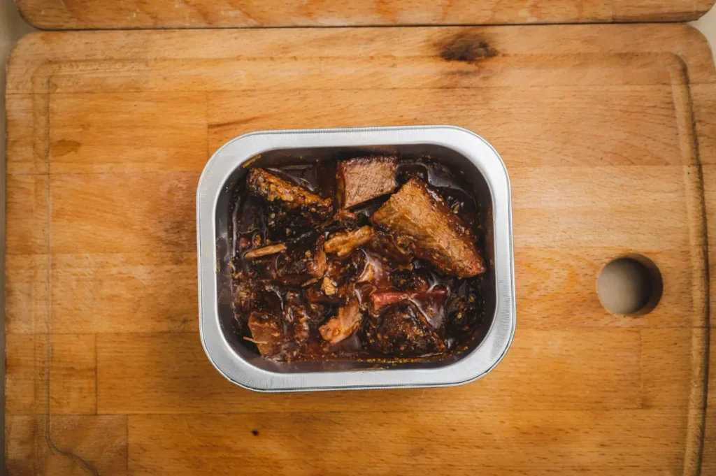 Open can of fish stew displayed.