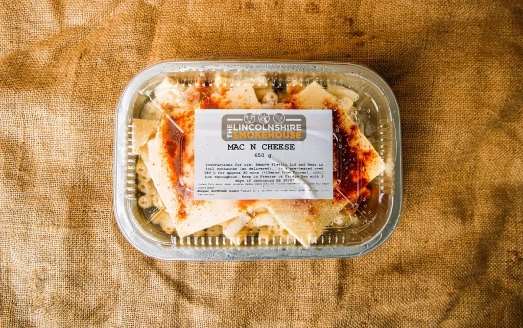 Packaged homemade mac and cheese in a clear container.