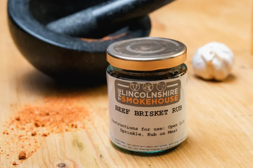 A can of Lincolnshire Smokehouse Beef Brisket Rub on a wooden surface.